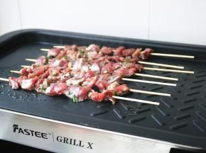 放上穿好的羊肉串开始煎烤。