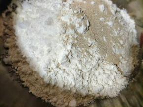 取一干净的容器倒入面粉，然后倒入发酵粉，放入少许白糖，倒入清水搅拌均匀；