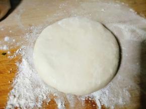 将揉好的面团切出一小块儿来，均匀揉开按压一下；