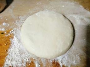 将揉好的面团切出一小块儿来，均匀揉开按压一下；