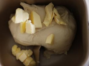 揉至面团光滑后。加入黄油，继续揉。