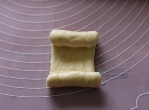 用面杖擀成长舌形，上下往中间卷起。