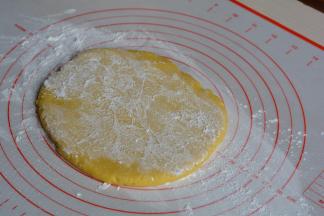 冷藏后的面饼取出，放在揉面垫上，为防粘可在饼上下撒少许面粉，或者用保鲜膜覆盖；