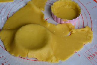 将挞模放在面片下面，用手轻轻按压，使饼皮贴合在挞模具内侧