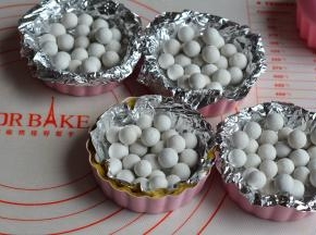 每个挞皮上铺一层锡纸，再撒上烘焙石，防止烤的时候挞皮变形