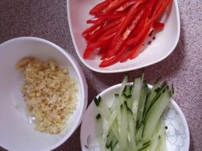 这时把黄瓜切丝。红椒切丝。姜蒜剁成沫。