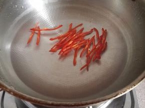 把鸡腿煮好之后捞出烧开水煮一下红椒丝。