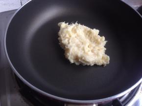 不粘锅里放入压成泥的榴莲肉，炒至水分收干