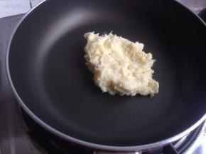 不粘锅里放入压成泥的榴莲肉，炒至水分收干