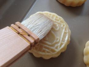 取出晾几分钟，在月饼表面刷薄薄一层蛋黄水