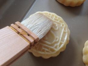 取出晾几分钟，在月饼表面刷薄薄一层蛋黄水