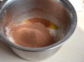 将另外3个鸡蛋加玉米油和凉水搅打均匀后筛入40克面粉和15克可可粉