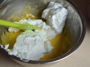 将蛋白糊在盆中划成两等份，取其中一份的1/3入原味蛋黄糊中