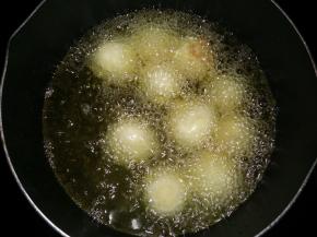 锅里倒入食用油，烧至热6成热时放入土豆球中小火炸。