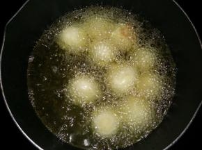 锅里倒入食用油，烧至热6成热时放入土豆球中小火炸。