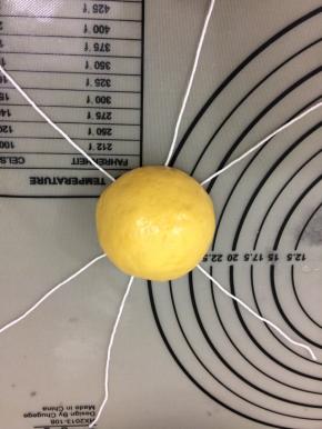 将包好的面团放在线中间