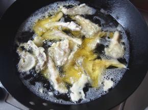 锅中加油，烧到六七成热，把蘑菇沾上糊，一个一个下入炸至变色