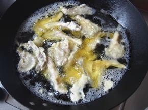 锅中加油，烧到六七成热，把蘑菇沾上糊，一个一个下入炸至变色