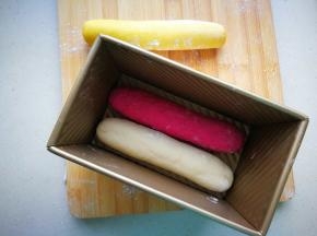 取出面团排气，滚成长条状，放入不沾吐司模具中。