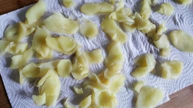 姜片分散开放在厨房纸上，吸收多余的水分。