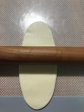 面团按扁，中间往前擀，中间往后擀，不要来回擀，也不要擀太长，大约10公分多一点即可。