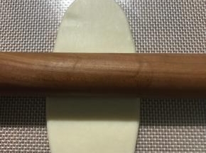 面团按扁，中间往前擀，中间往后擀，不要来回擀，也不要擀太长，大约10公分多一点即可。