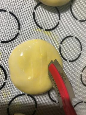 按扁，成1.5公分厚左右的饼，刷一层蛋黄液，用小刀割口