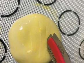 按扁，成1.5公分厚左右的饼，刷一层蛋黄液，用小刀割口