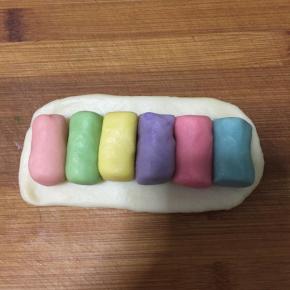 油皮擀成长方形，不用太大，正好包住六个油酥即可。油酥按喜欢的颜色顺序摆放。