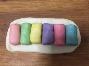 油皮擀成长方形，不用太大，正好包住六个油酥即可。油酥按喜欢的颜色顺序摆放。