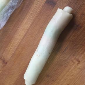 从一边由上至下卷好，收口朝下，依次卷好，盖保鲜膜松弛十分钟。