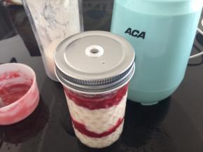 准备覆盆子果酱，先倒入1/4的水蜜桃奶昔，再用勺子勺一层覆盆子果酱，再倒入水蜜桃，依次倒好