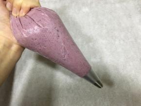 取自己喜欢的裱花嘴形状，放入裱花袋中，把曲奇糊舀到裱花袋中