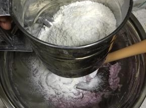 接着用面粉筛将低筋面粉筛入到黄油紫薯中