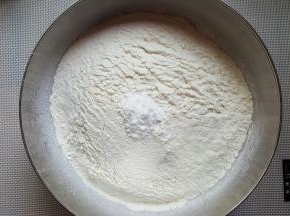 将面粉过筛加入小苏打，搅拌均匀。