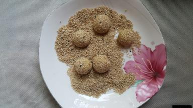 小的面团上沾白芝麻后滚圆（小面团可以放在蘸有水的布上滚湿后沾上芝麻）。
