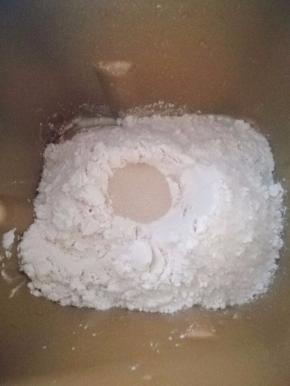 3.加入面包粉，在面包粉上挖个洞，埋入酵母，面包机开始揉面程序。