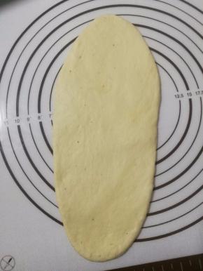 7.取一个面团，擀成长长的椭圆形，再由上往下滚成卷。三个面团重复步骤。