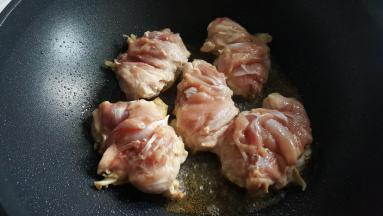 把吸干水份的鸡腿，皮向下放在油中煎炸