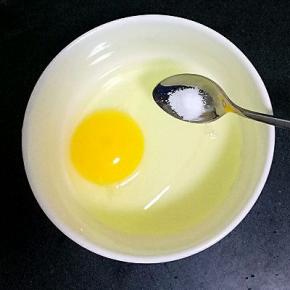 鸡蛋打入容器中，放入适量盐和温水打散