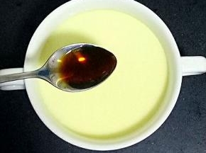小勺里倒入少许生抽和香油，淋入蒸好的鸡蛋羹中