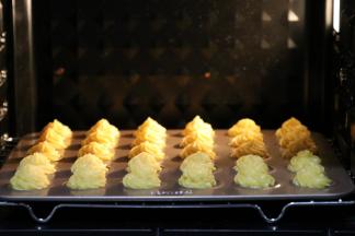 放入最底层。关上烤箱后千万千万就不能开烤箱了，以免出现泡芙表面蒸发水分时，烤箱内温度偏差，引起回缩现象。