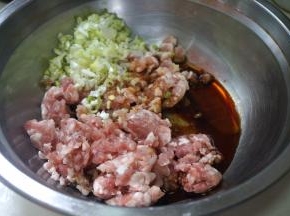 猪肉馅中倒入适量的盐、生抽、香油，一棵大葱切末