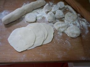 饧好的面团取出，放在案板上，搓成长条，再切成大小均匀的剂子，跟平时包饺子的差不多大，擀成一样薄厚的皮，因为是烫面的，所以不用边缘薄中间厚