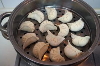 将包好的饺子码放在抹了一层油的蒸屉上，盖盖子，大火上汽后蒸8-10分钟