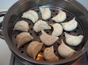 将包好的饺子码放在抹了一层油的蒸屉上，盖盖子，大火上汽后蒸8-10分钟