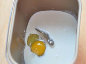 将牛奶和鸡蛋放入面包桶中，再放入糖和盐。