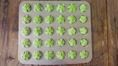 裱花嘴装入裱花袋顶部，面糊装入裱花袋中，垂直对准模具挤出樱花图案