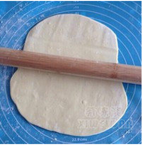 洒少许面粉，压扁后用擀面杖擀成圆形长面片