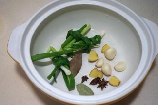 小葱打结，姜切厚片，八角、香叶、大蒜入锅中